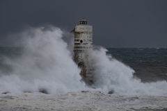 Powerful waves crashing against a Mangiabarche lighthouse during a hurricane, symbolizing resilience and the forces of nature